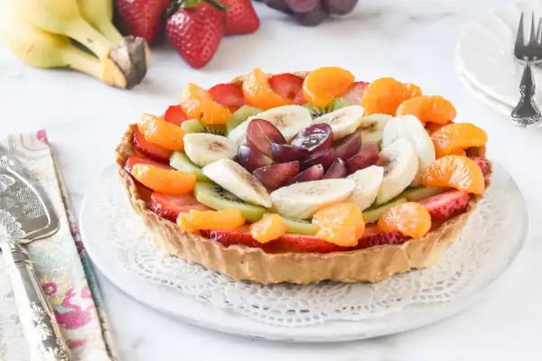 Deliciosa tarta de fruta natural, cubierta con fresas, kiwi, plátano, mandarina y uvas. ¡Un postre fresco y colorido!
