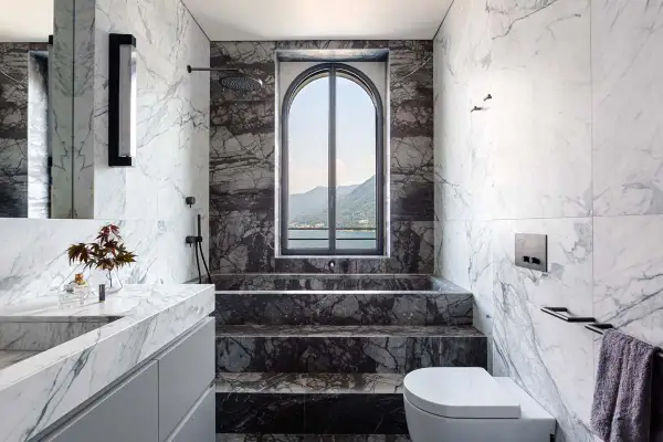 Bagno di lusso con vasca e doccia in muratura, rivestimenti in marmo e vista panoramica. Idee per una doccia in muratura moderna.