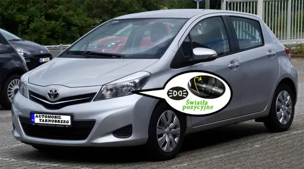 Srebrny Toyota Yaris z włączonymi światłami pozycyjnymi. Pokazano przełącznik świateł.