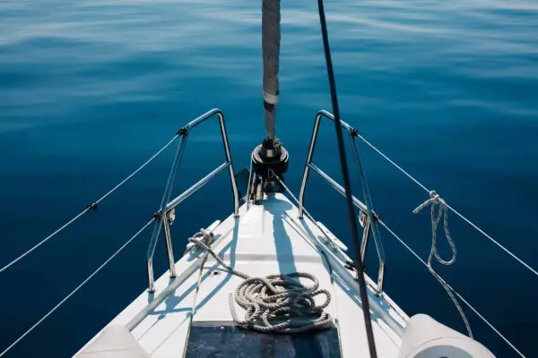 Prua di una barca a vela su un mare blu calmo. La prevalenza di una pompa è un concetto che non si applica a questa immagine.