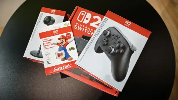 Pudełka z akcesoriami do Nintendo Switch: kontroler Pro, karta microSD 256 GB z Mario i kamera.