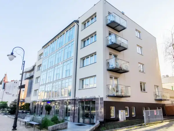 Nowoczesny hotel Lazur Świnoujście z przeszkloną fasadą i balkonami.
