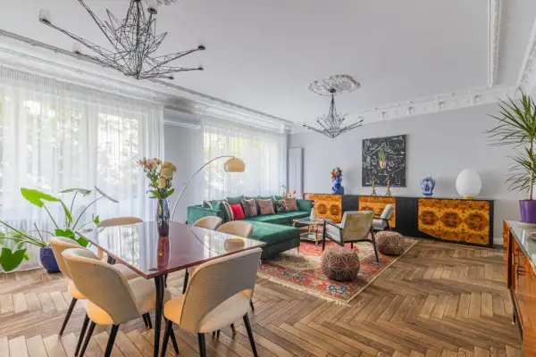 Elegancki salon z zieloną kanapą i jadalnią, idealny do zamieszkania. Ten dom na sprzedaż w Krakowie zachwyca stylem.