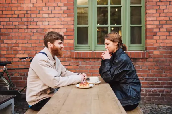 Para dowiedzieć się, jak dojść do siebie po rozstaniu, siedzi przy stoliku, pijąc kawę i jedząc ciastko.