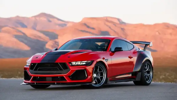 Czerwony Ford Shelby z czarnymi pasami i spojlerem na tle pustynnych gór.