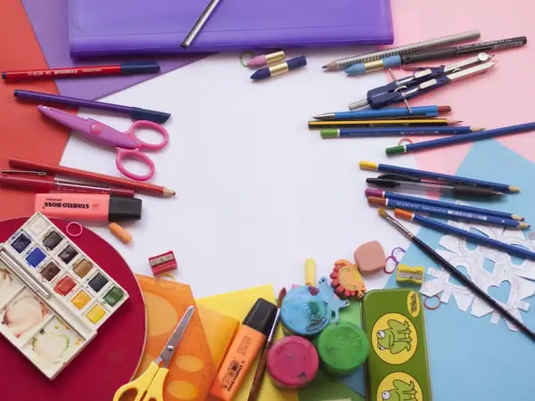 Bunt und ordentlich: Buntstifte, Scheren, Wasserfarben und mehr liegen bereit, um Schulsachen zu organisieren.