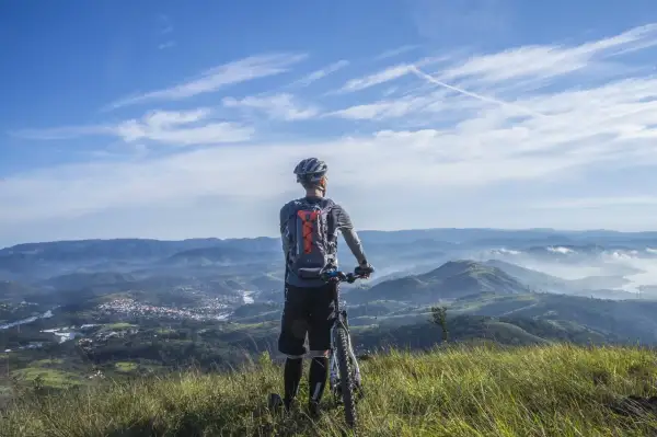 Rowerzysta na szczycie górskiego krajobrazu, podziwiający widok. Przygoda w Beskidach na rowerze.