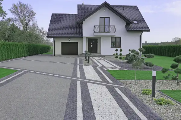 Nowoczesny podjazd z kruszywa i kostki brukowej, tworzący ciekawe wzory. Inspiracje dla Twojego ogrodu.