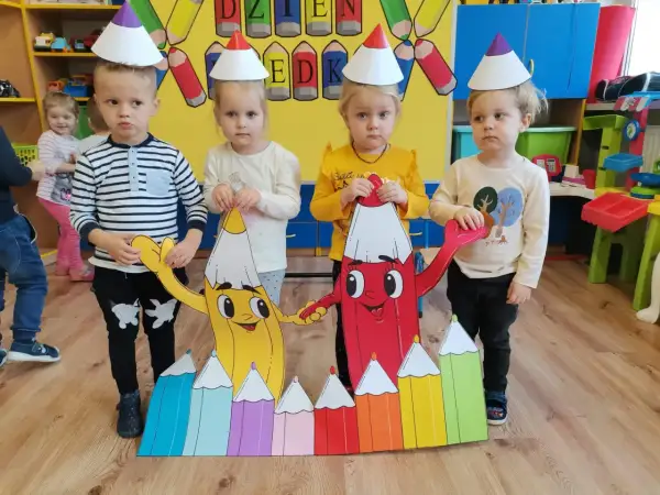 Dzieci w czapkach urodzinowych świętują dzień kredki. Pomysły na kreatywne zabawy z kolorowymi kredkami.