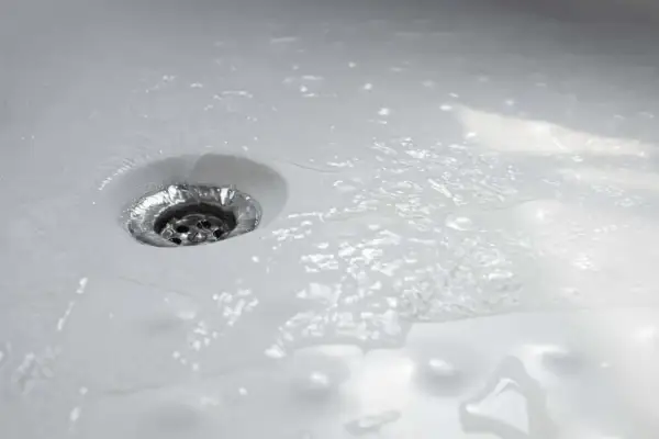 Acqua che scorre nello scarico della doccia, un segno che la pulizia è stata efficace.