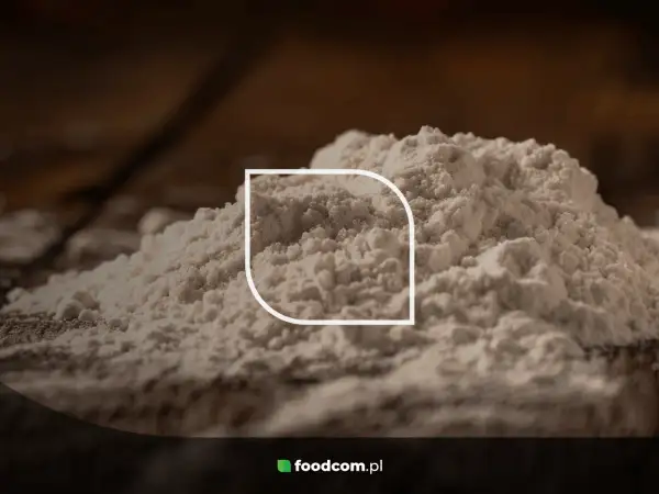 Stos białego proszku, być może mąki, z widocznym logo foodcom.pl. Ten ci 77891 jest idealny do wypieków.