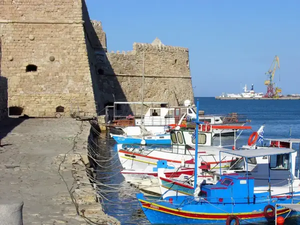 Port w Rethymno, Kreta. Listopad. Słoneczna, choć chłodna pogoda sprzyja spacerom po nabrzeżu wśród kolorowych łodzi rybackich i potężnej twierdzy.
