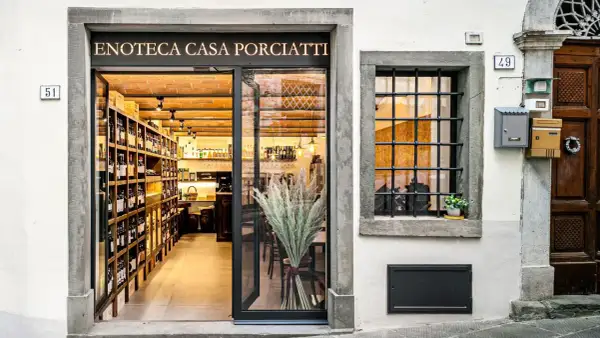 Enoteca Casa Porciatti, sklep z winami w sercu Chianti, zaprasza do degustacji. Wnętrze pełne butelek i ceglanych ścian.