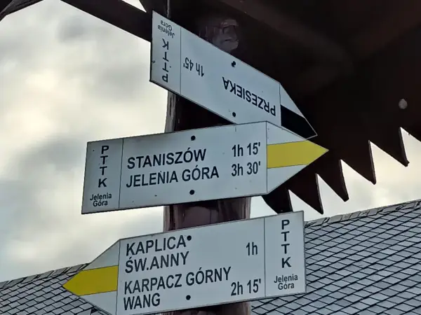 Droga do Kaplicy Św. Anny w Karpaczu Górnym. Znaki PTTK wskazują trasę na Przesiekę, Staniszów i Jeleniej Górę.