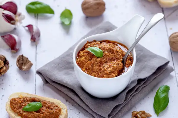 Pesto di pomodori secchi e noci, gustoso e profumato, pronto per essere spalmato su pane croccante o per condire la pasta.