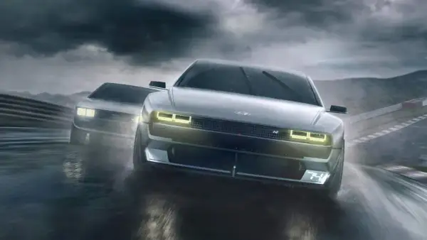 Dwa Hyundai N Vision 74 pędzą po mokrym torze wyścigowym w deszczu.