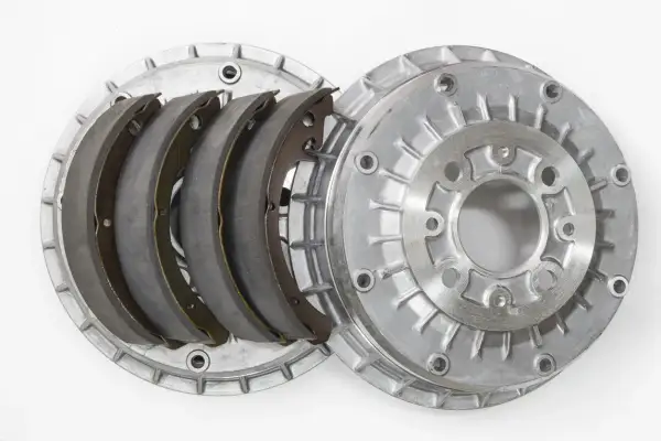 Pièces détachées d'un frein à tambour : mâchoires neuves et tambour en aluminium.