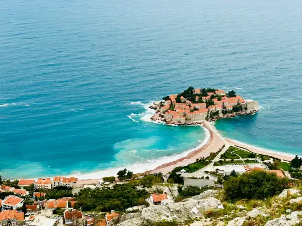Wyspa Sveti Stefan, znana z pięknych budva plaże, połączona z lądem piaszczystą mierzeją.