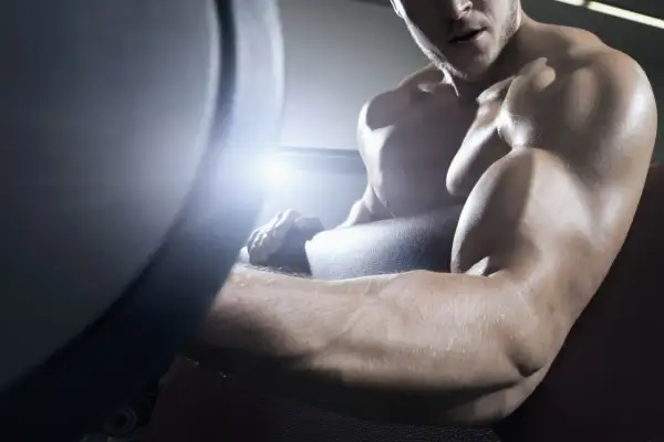 Muskulöser Mann trainiert im Fitnessstudio, seine Arme sind definiert und ohne Fettansatz.