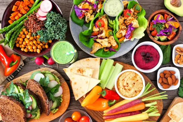 Kolorowe warzywa, hummus, smoothie i pieczywo – to wszystko pokazuje, co to jest weganizm: pyszne i zdrowe jedzenie bez produktów odzwierzęcych.