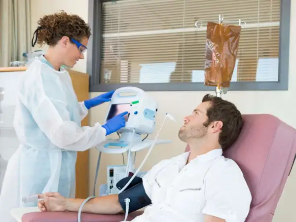 Eine Krankenschwester überwacht die Vitalwerte eines Patienten während einer Chemotherapie. Die Frage, welche Chemo am schlimmsten ist, beschäftigt viele.
