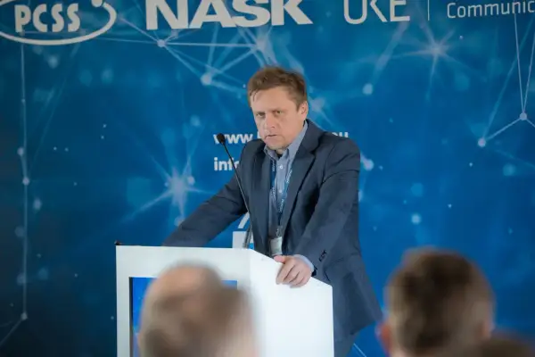 Mężczyzna w garniturze przemawia na konferencji. Dowiadujemy się, ctf co to jest, dzięki jego prezentacji.