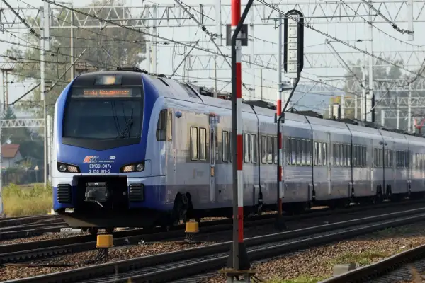 Niebieski pociąg PKP Intercity ED160-007a, kursujący na trasie Zamość - Kraków, zbliża się do stacji.