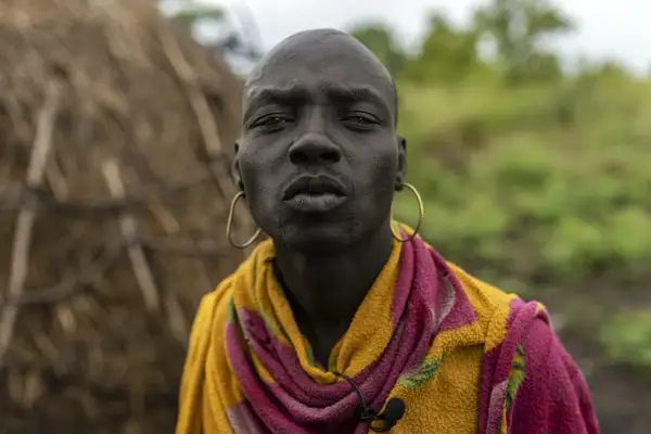 Uomo Mursi in Etiopia, con grandi orecchini dorati e un colorato scialle.