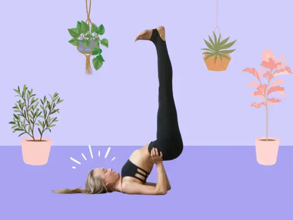 Donna in posizione yoga Viparita Karani, con le gambe sollevate. I viparita karani benefici sono molti, tra cui rilassamento e circolazione.