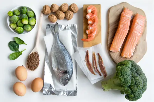 Różnorodne produkty bogate w omega 3: łosoś, sardele, krewetki, ryba morska, orzechy, siemię lniane, brokuły, brukselka, szpinak i jajka.