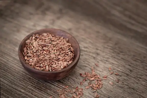 Braune Leinsamen in einer Holzschale, bereit, um leinsamenmehl selber machen zu können.