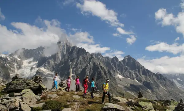 Groupe de randonneurs profitant d'une magnifique randonnée à Chamonix, avec des montagnes imposantes en arrière-plan.