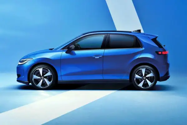 El nuevo Volkswagen ID.2, un coche eléctrico azul brillante, se presenta en un estudio con un fondo azul y líneas blancas.