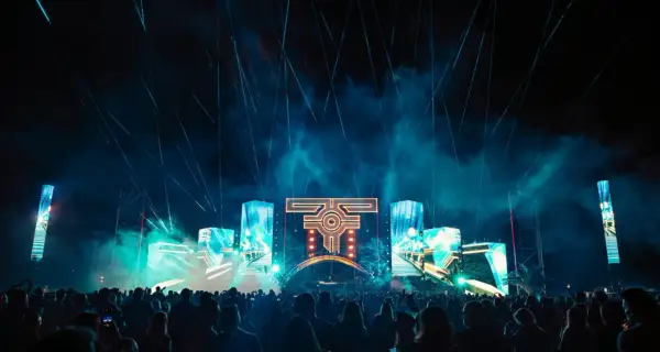 Nocny festiwal muzyczny z laserami i ekranami LED. Tłum ludzi bawi się przy muzyce na żywo.