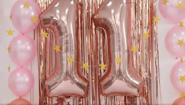 Globos rosas y dorados con estrellas, formando el número 11. ¡Ideas para celebrar tu cumpleaños!