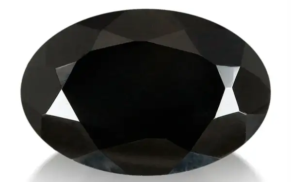 Espinela negra ovalada, facetada, con reflejos de luz que resaltan sus propiedades.