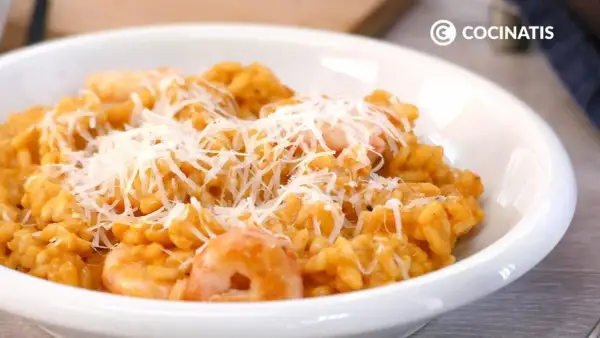 Un cremoso risotto de gambas, coronado con queso rallado, listo para disfrutar.