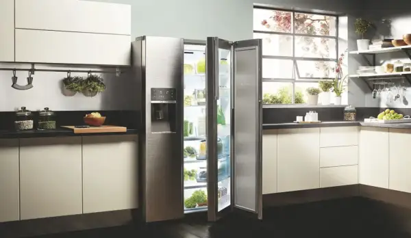 Cuisine moderne avec réfrigérateur ouvert, rempli de produits frais. L'inconvénient froid statique est évité grâce à une organisation optimale.