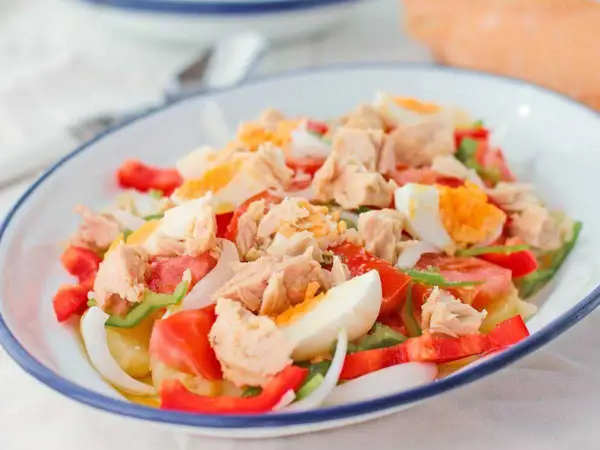 Ensalada campera con atún desmigado, huevo duro, tomate, pimiento y cebolla. Un plato fresco y completo.