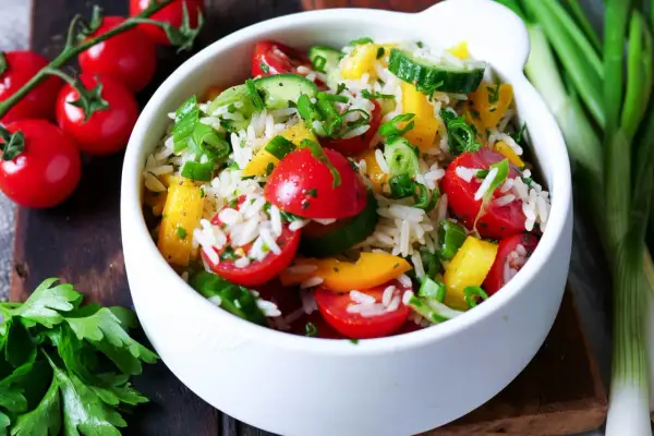 Frischer Reissalat mit Tomaten, Gurken und Paprika. Ein leichtes und gesundes reissalat rezept für den Sommer.