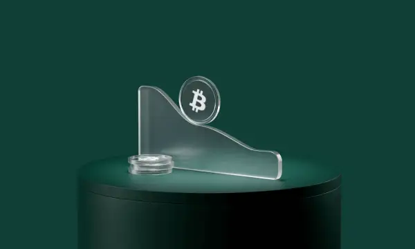 Kryptowaluty spadają, symbolizując co to bessa. Bitcoin na szczycie pochylonej platformy, obok stos monet.