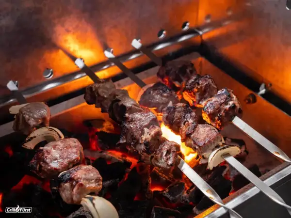 Fleischspieße mit Zwiebeln brutzeln über glühender Kohle. Perfekt, welches Fleisch zum Grillen!