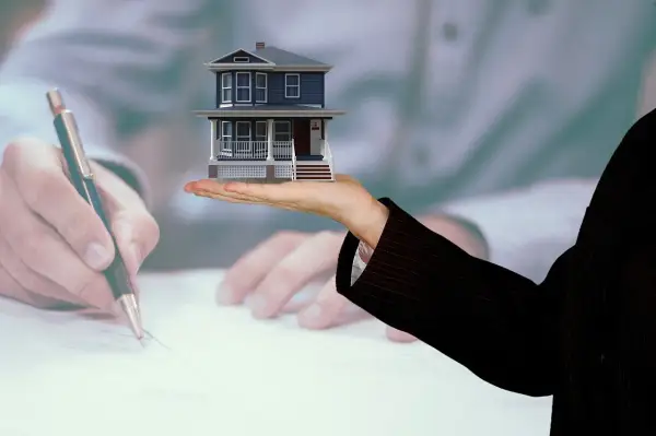 Mano che firma un accordo per vendere casa con genitore in casa di riposo.