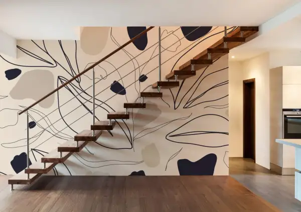 Escalier moderne avec un mur à l'effet peinture, orné de formes abstraites et de lignes organiques dans des tons neutres.