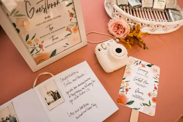 Wpis do księgi gości z polaroidami i życzeniami. Aparat Instax czeka na uwiecznienie chwil.