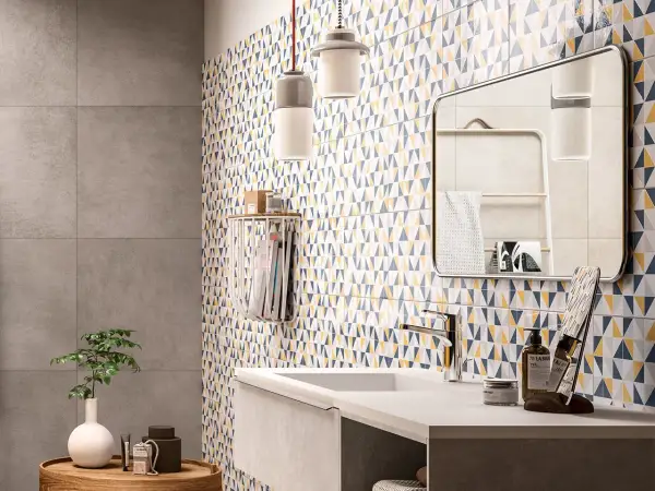 Bagno moderno con parete a triangoli colorati, ideale per chi cerca idee su come rinnovare pavimento in ceramica con stile.