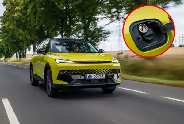 Żółty SUV z fabrycznym LPG na drodze. W powiększeniu widać korek wlewu gazu.