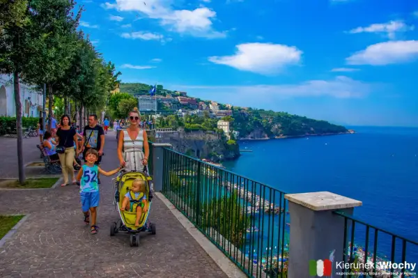 Rodzina spaceruje promenadą, podziwiając piękne widoki na morze i miasto. To idealne miejsce na odkrywanie atrakcji Sorrento.
