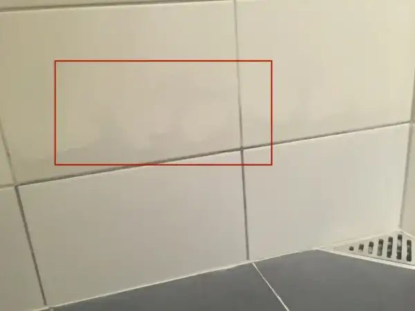 Fuktskada badrum tecken syns som mörka fläckar på kaklet. Vatten har trängt in.