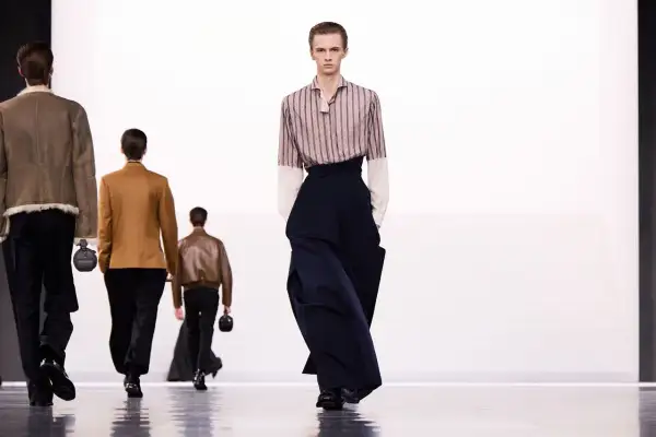 Sfilata di moda maschile: un modello indossa pantaloni ampi blu scuro. Taglia 16 a cosa corrisponde?